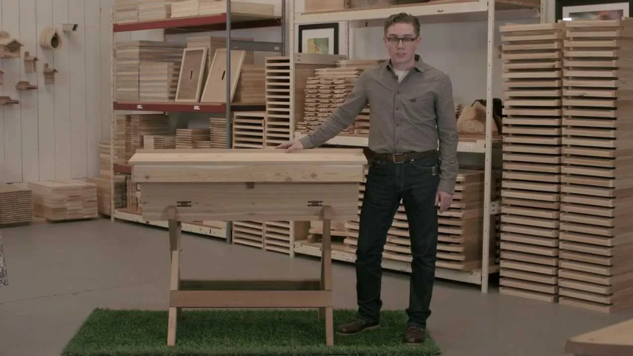 Advanced Apiculture beekeeper showing top bar beehive ventilation